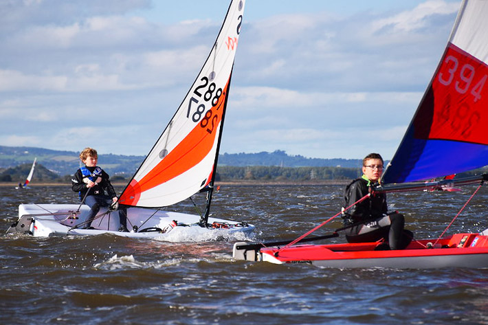 Feva and Topper neck-and-neck>fter three successful races, the fleet came ashore for a late (gourmet) lunch. When parent volunteer <strong>Richard</strong> is in the galley, the food at Starcross junior events is renowned far and wide. Today was no exception, wth four types of pasta dishes, freshly cooked to ancient Sicilian recipes by Richard and his team of helpers. This was rounded off by home-made cakes and tea, before the prizegiving.</p> <p>Well done to all the sailors.</p> <ul> <li>Full results (and photo album) - see <a href=